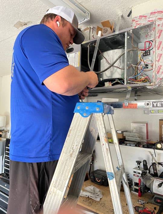 Mega Cooling technician servicing an indoor air handler